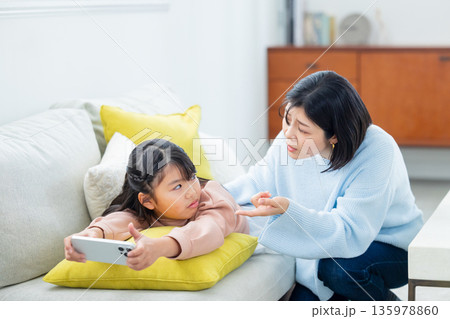スマホで遊ぶ小学生の女の子 スマホで遊ぶ小学生の女の子 135978860