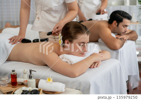 Hot stone massage at spa salon in luxury resort. Quiescent Hot stone massage at spa salon in luxury resort. Quiescent 135979250