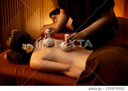 Hot herbal ball spa massage body treatment with couple customer. Quiescent Hot herbal ball spa massage body treatment with couple customer. Quiescent 135979302