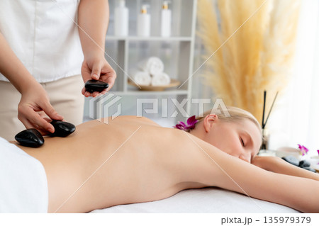 Hot stone massage at spa salon in luxury resort. Quiescent 135979379