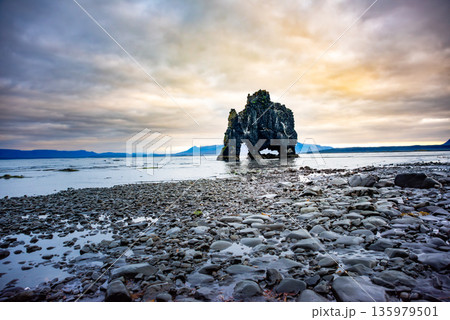 Hvitserkur, a striking basalt sea stack, stands tall on the shores of Vatnsnes Peninsula in Iceland. Its unique shape is beautifully mirrored in the calm waters, creating a natural reflection Hvitserkur, a striking basalt sea stack, stands tall on the shores of Vatnsnes Peninsula in Iceland. Its unique shape is beautifully mirrored in the calm waters, creating a natural reflection 135979501
