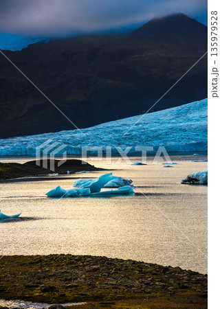 Discover the stunning Fjallsarlon Lagoon in Iceland, featuring large icebergs floating in tranquil waters under a blue sky. Ideal for nature enthusiasts and photographers. Discover the stunning Fjallsarlon Lagoon in Iceland, featuring large icebergs floating in tranquil waters under a blue sky. Ideal for nature enthusiasts and photographers. 135979528