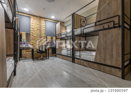 Spacious loft hostel dormitory with bunk beds at night 135980397