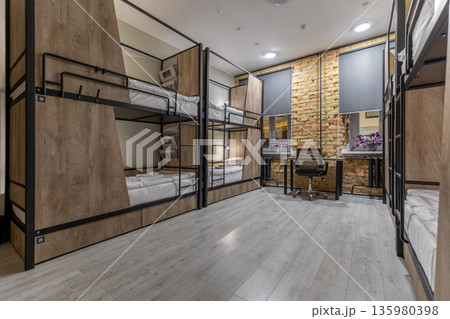 Modern loft hostel dormitory interior with bunk beds at night 135980398