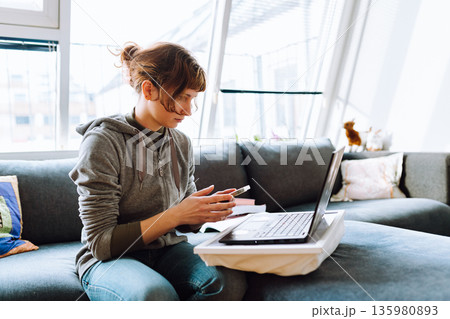 e-shopping while sitting on couch e-shopping while sitting on couch 135980893