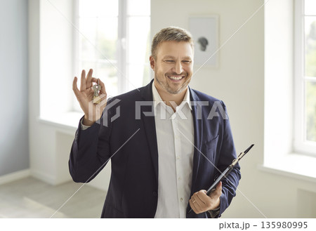 Portrait Of Happy Realtor Holding Keys To A New Home 135980995