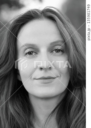 Portrait Beautiful Woman Standing Outdoors Looking at Camera and Smiles. Self-belief, Female Empowerment, Confidence, Hope. Portrait Beautiful Woman Standing Outdoors Looking at Camera and Smiles. Self-belief, Female Empowerment, Confidence, Hope. 135981749