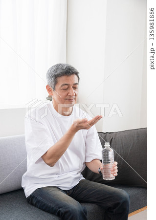 薬を飲む男性 135981886
