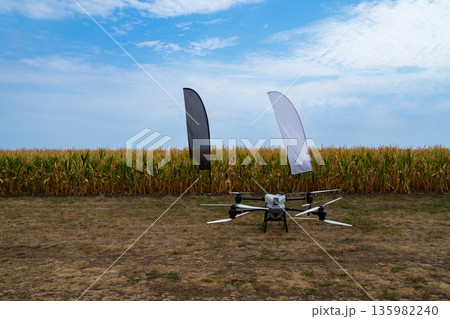 Drone in a Cornfield: Aerial Farming Setup with Flags in Open Field 135982240