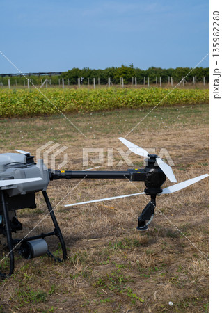 Aerial agricultural drone on a dry field with propellers ready for precision farming and modern agriculture 135982280