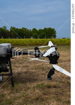 Close-up drone with propellers ready to survey an agricultural field in a rural landscape Close-up drone with propellers ready to survey an agricultural field in a rural landscape 135982297