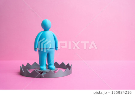 A blue male figurine as bait in a trap. A male figurine about to be trapped. Valentine's Day. Relationships and dating. Emotional manipulation theme, modern romance risks and trust issues A blue male figurine as bait in a trap. A male figurine about to be trapped. Valentine's Day. Relationships and dating. Emotional manipulation theme, modern romance risks and trust issues 135984216