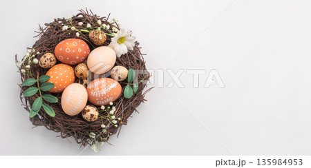 Easter nest with hand-painted eggs on a light background 135984953