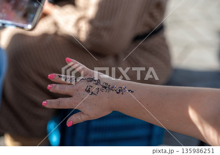 Hand decorated with henna in a market stall in Marrakech during a sunny day Hand decorated with henna in a market stall in Marrakech during a sunny day 135986251