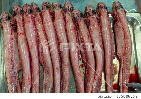 Freshly prepared fish displayed neatly on a metal tray in a market setting 135986258