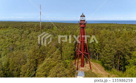 Ruhnu lighthouse stands amid lush greenery on Ruhnu Island in Estonia near the sea 135986259