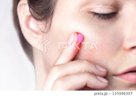 A drop of capsule pink cream on the finger of a woman. Caucasian woman applies cream to her face. Swatch of pink popular Niacinamide Capsule Cream. isolated on pink background photo A drop of capsule pink cream on the finger of a woman. Caucasian woman applies cream to her face. Swatch of pink popular Niacinamide Capsule Cream. isolated on pink background photo 135986307