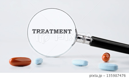 A polished magnifying glass brings the word Treatment into sharp focus against a pure white setting 135987476
