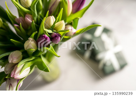 Spring floral background. Fresh tulips flowers bouquet and gift boxes. Mother's day. Macro photography Spring floral background. Fresh tulips flowers bouquet and gift boxes. Mother's day. Macro photography 135990239