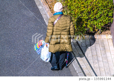 日本の横浜都市景観光と“陰”…高齢化社会 杖の高齢女性(マスク姿)。買い物帰り、左手は手袋… 日本の横浜都市景観光と“陰”…高齢化社会 杖の高齢女性(マスク姿)。買い物帰り、左手は手袋… 135991144