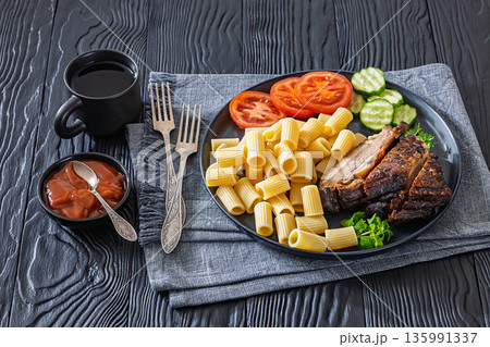 roasted pork ribs with pasta and fresh vegetables 135991337