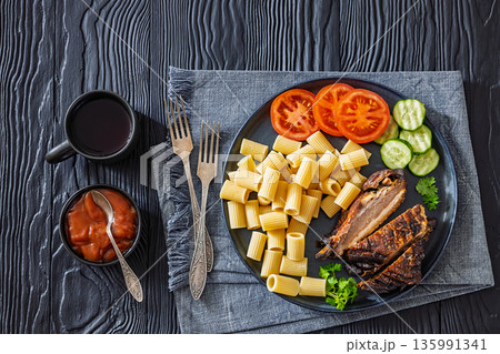 roasted pork ribs with pasta and fresh vegetables 135991341