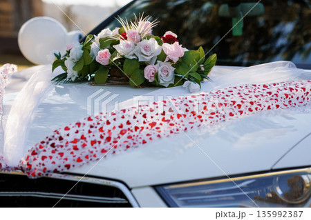 Elegant White Wedding Car Decorated with Pink and White Rose Bouquet and Heart Patterned Ribbon Elegant White Wedding Car Decorated with Pink and White Rose Bouquet and Heart Patterned Ribbon 135992387