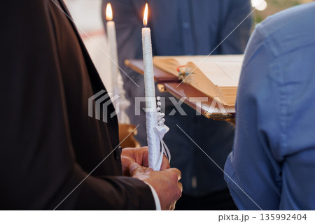 Wedding Ceremony Ritual with Lit White Candles and Pearl Decorations During Religious Service Wedding Ceremony Ritual with Lit White Candles and Pearl Decorations During Religious Service 135992404