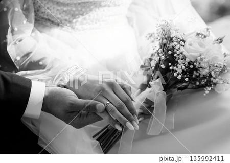 Black and White Wedding Portrait of Bride and Groom Holding Hands with Bouquet and Rings 135992411