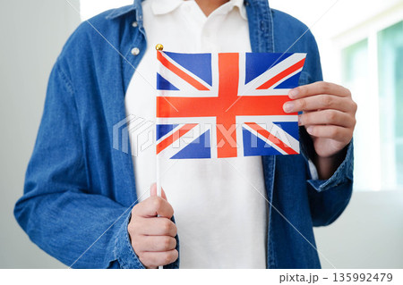 Learning English, Asian teenage student holding book with flag for language program education. Learning English, Asian teenage student holding book with flag for language program education. 135992479