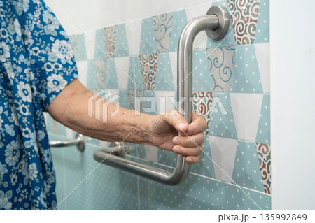 Asian elderly woman use safety handrail in bathroom. Asian elderly woman use safety handrail in bathroom. 135992849