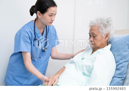Asian doctor checking and treat elderly woman patient health in hospital. 135992983