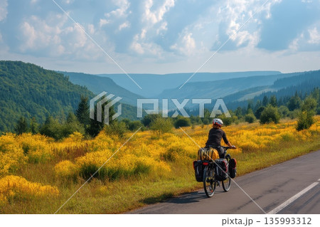 Cyclist with Backpack Riding Through Scenic Landscape Surrounded by Lush Greenery and Flowers Cyclist with Backpack Riding Through Scenic Landscape Surrounded by Lush Greenery and Flowers 135993312