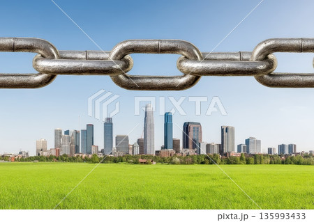 Metallic Chain Links Floating Above a Green Field and City Skyline Under a Clear Sky Metallic Chain Links Floating Above a Green Field and City Skyline Under a Clear Sky 135993433