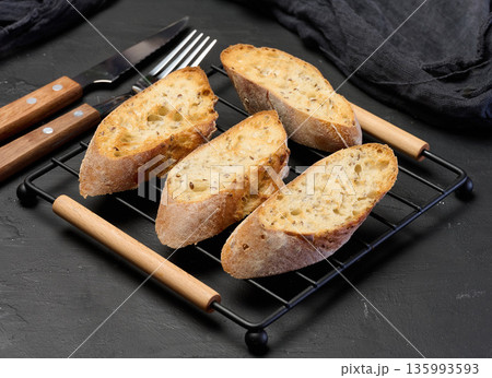 Slices of toasted grain baguette on the grill 135993593