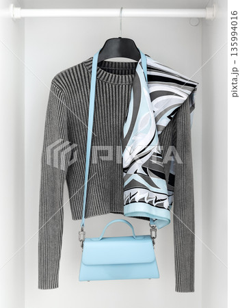 Minimalist outfit with knit sweater, scarf and handbag in wardrobe Minimalist outfit with knit sweater, scarf and handbag in wardrobe 135994016