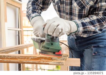 Carpenter at work, restoring an old wooden window. Carpentry. 135994071