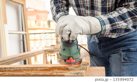 Carpenter at work, restoring an old wooden window. Carpentry. Carpenter at work, restoring an old wooden window. Carpentry. 135994072