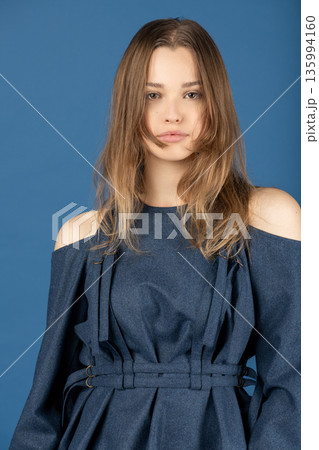Young woman wearing blue denim dress portrait 135994160