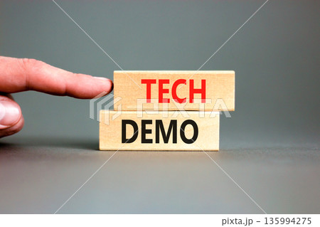 Tech demo symbol. Concept word Tech demo on beautiful wooden blocks. Beautiful grey paper background. Businessman's hand. Business tech demo concept. Copy space. Tech demo symbol. Concept word Tech demo on beautiful wooden blocks. Beautiful grey paper background. Businessman's hand. Business tech demo concept. Copy space. 135994275