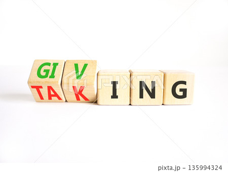 Giving or taking symbol. Concept words Giving or Taking on beautiful wooden cubes. Beautiful white table white background. Business, giving or taking concept. Copy space. 135994324