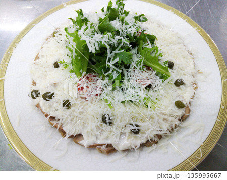 veal slices with mayonnaise, tuna and caper sauce on a white plate 135995667