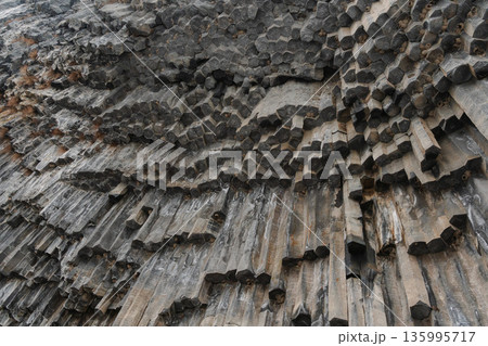 Vertical basalt columns form dense geometric patterns at the Symphony of Stones, dark volcanic rock creates dramatic texture and natural rhythm Vertical basalt columns form dense geometric patterns at the Symphony of Stones, dark volcanic rock creates dramatic texture and natural rhythm 135995717