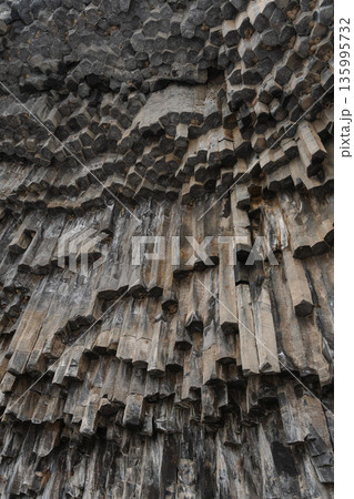 Vertical basalt columns form dense geometric patterns at the Symphony of Stones, dark volcanic rock creates dramatic texture and natural rhythm Vertical basalt columns form dense geometric patterns at the Symphony of Stones, dark volcanic rock creates dramatic texture and natural rhythm 135995732
