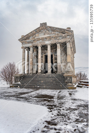 Armenia, Garni - January 10, 2026: Snow-covered Garni Temple stands on plateau, its classical colonnade framed by winter mountains and overcast sky Armenia, Garni - January 10, 2026: Snow-covered Garni Temple stands on plateau, its classical colonnade framed by winter mountains and overcast sky 135995739
