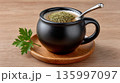 Hot drink served in black cup with herbs on top and green parsley leaf 135997097