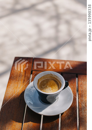 Cup of black coffee on a table in a street cafe. 135998338