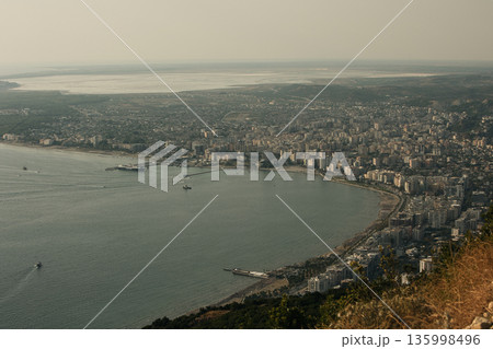 A flock of seagulls flying above the coastline near an industrial pier in Vlora, Albania, photographed on August  2025. 135998496