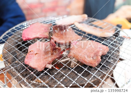 炭火網焼きで焼かれる牛タンのクローズアップ 135998724