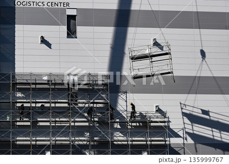 物流施設新築現場におけるクレーンを用いた足場撤去作業 物流施設新築現場におけるクレーンを用いた足場撤去作業 135999767